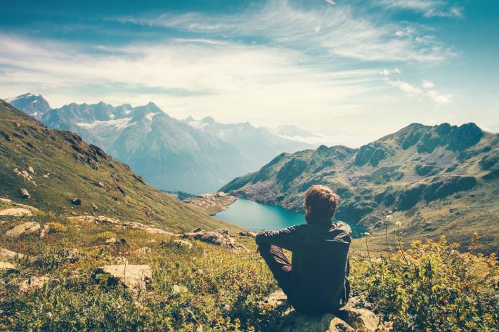 Man reflecting in the mountains trying to find himself during an unexpected adventure.