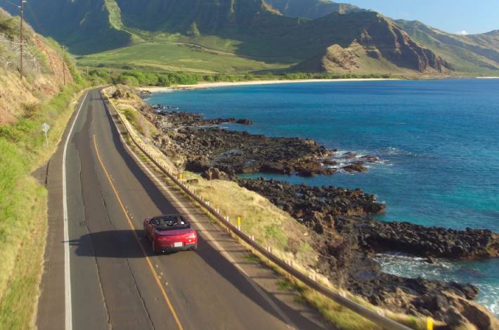 Auto rijdt langs de kust tijdens een surprise roadtrip