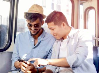 Two boys on a bus looking at a phone during a GPS game