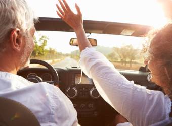 Happy couple driving a car during a surprise roadtrip