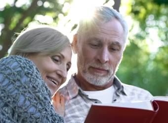 Senior couple reading a surprise celebration photoalbum