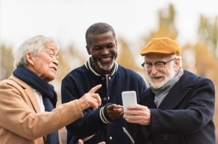 Oude vrienden navigeren op een telefoon tijdens een verrassingsverjaardagsreis