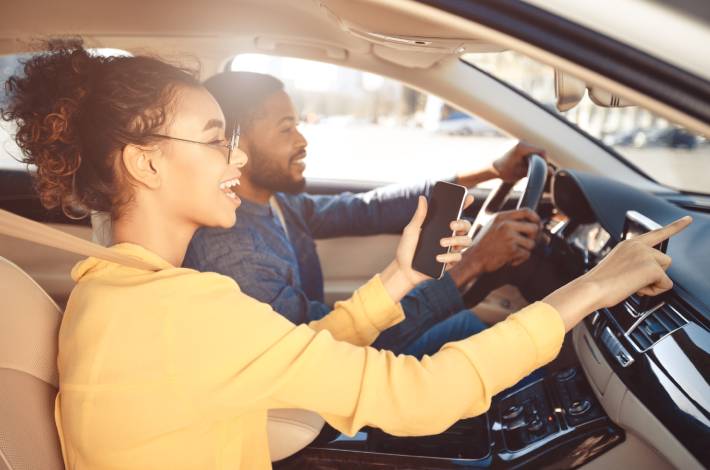 Jongen en meisje rijden in een auto tijdens een verjaardag GPS game